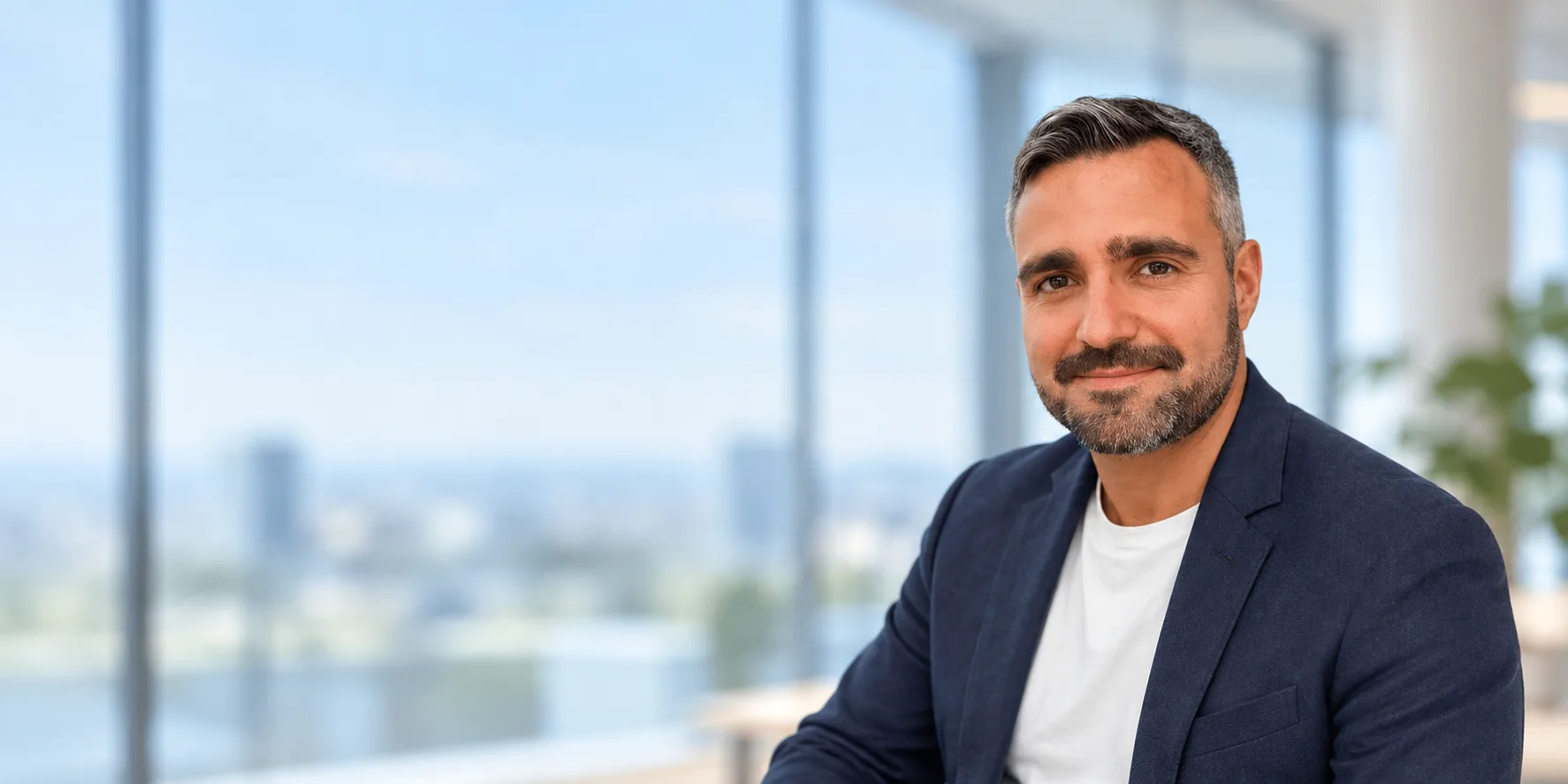Retrato corporativo de Joan Aranda en una oficina luminosa, creado con IA a partir de su fotografía.